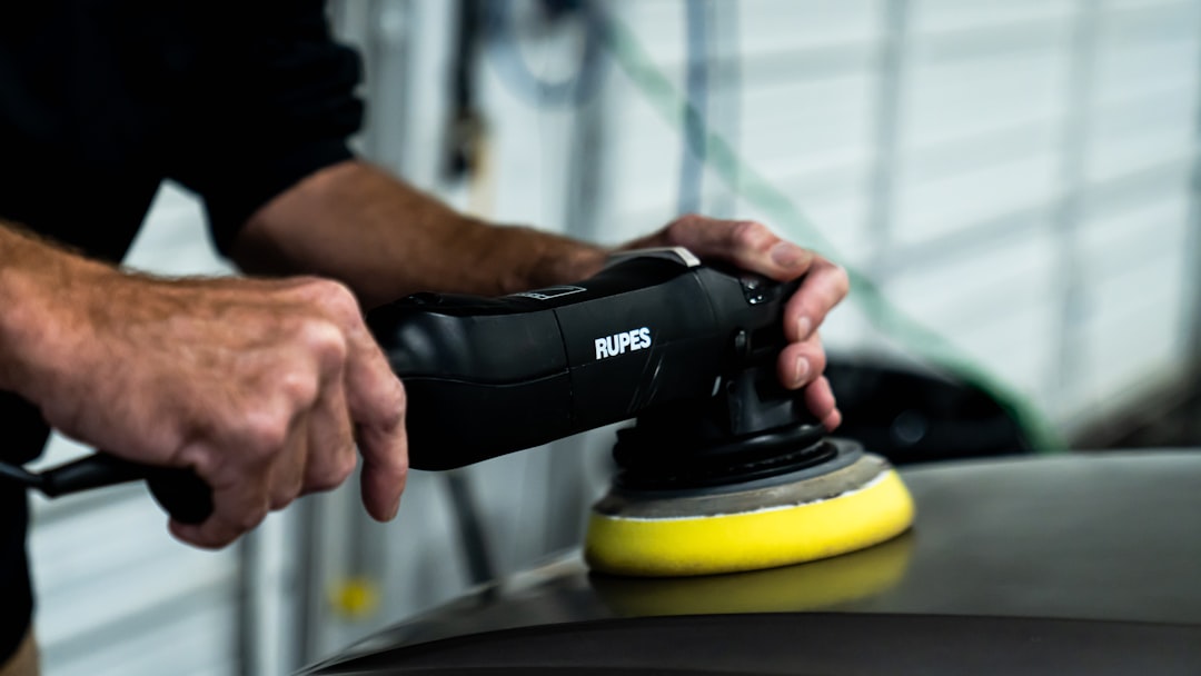 a man sanding a car with a polisher